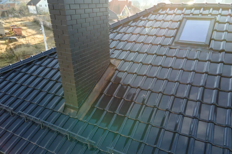 Fenêtre de toit et cheminée en brique sur une toiture en tuiles